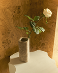 Greg Natale Celesta Vase Light Emperador with a white rose on a sculptural pedestal