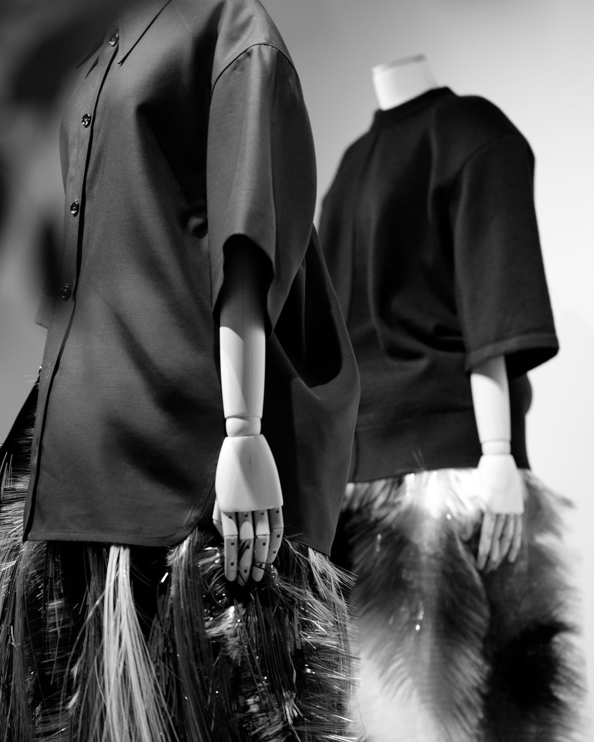 Two mannequins in dark short-sleeved tops, photographed in black and white.