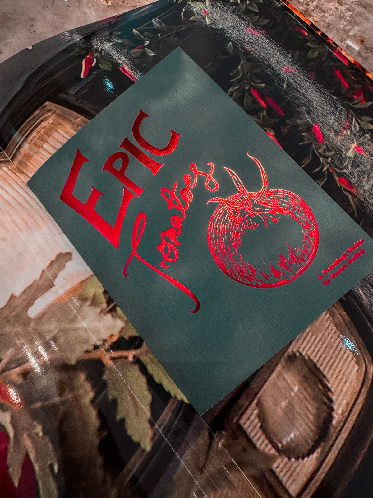 An Epic Tomatoes volume photographed among illustrated pages