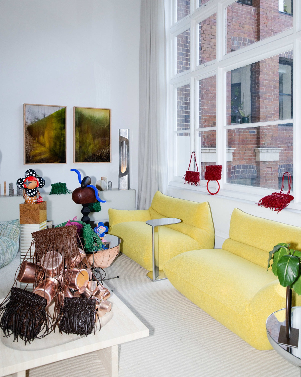 A-ESQUE bags and sculptural objects beside Adam Goodrum’s yellow Billo sofa.