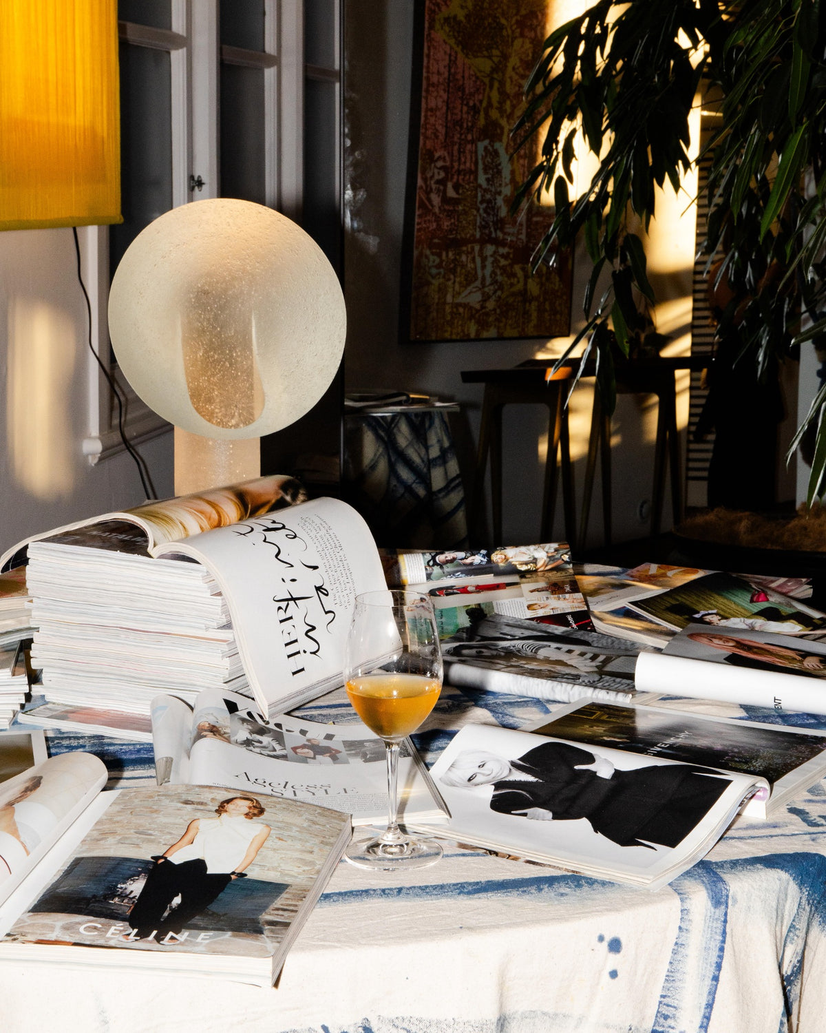 A closer look at the table, with a glowing spherical light and stacked books.