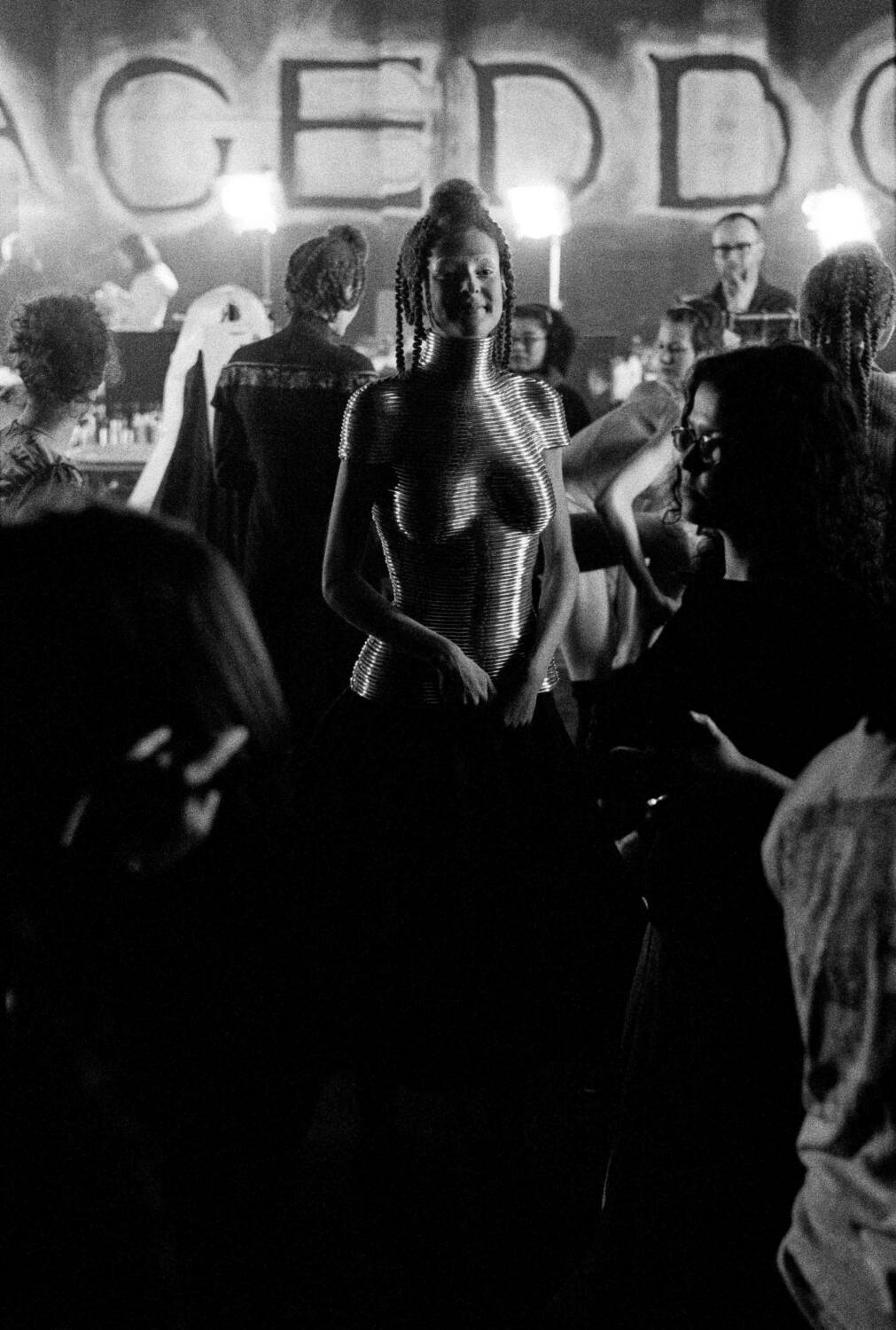 A model wearing Shaun Leane’s Coiled Corset amid a backstage crowd