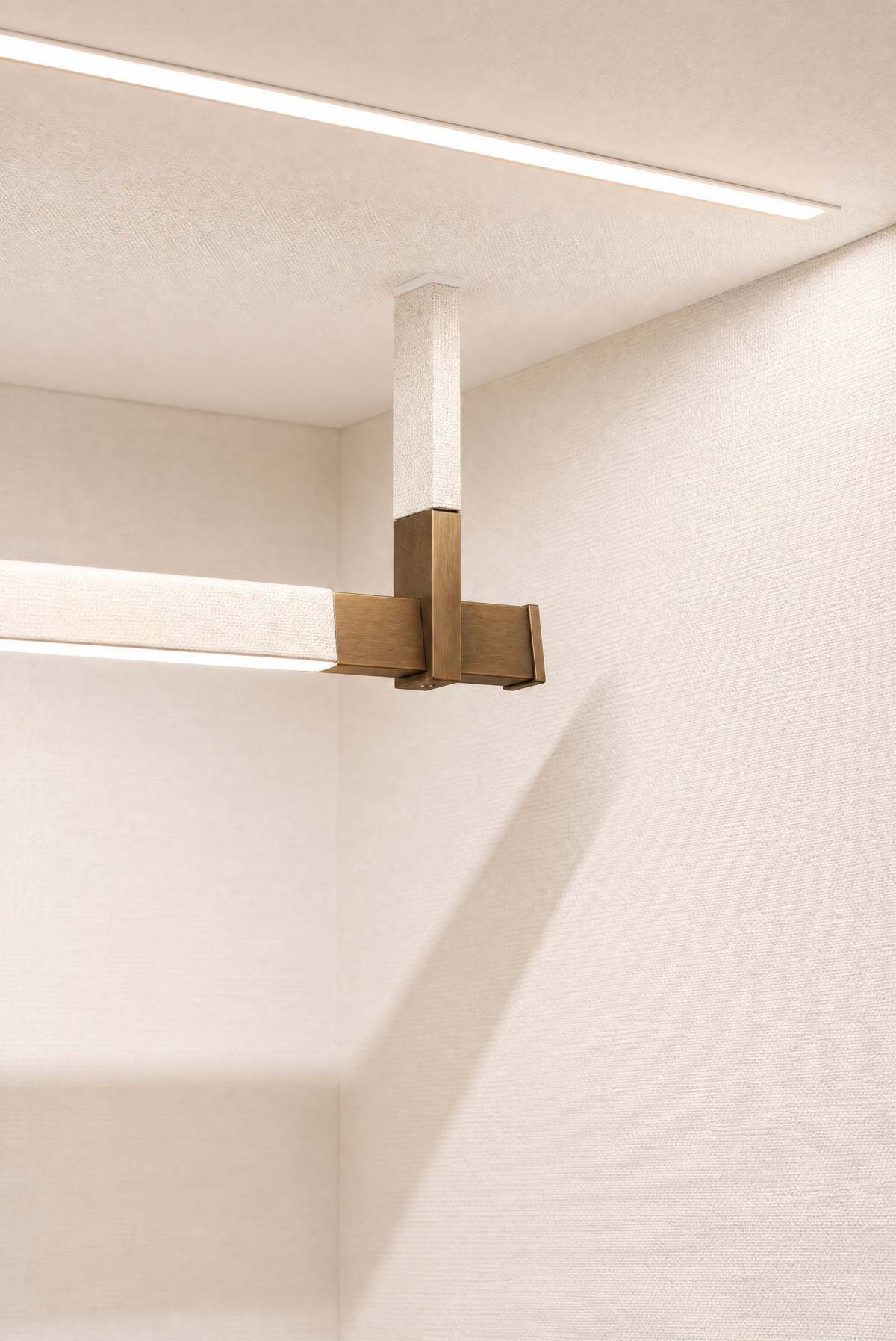 A bronze fitting against a textured cream wall