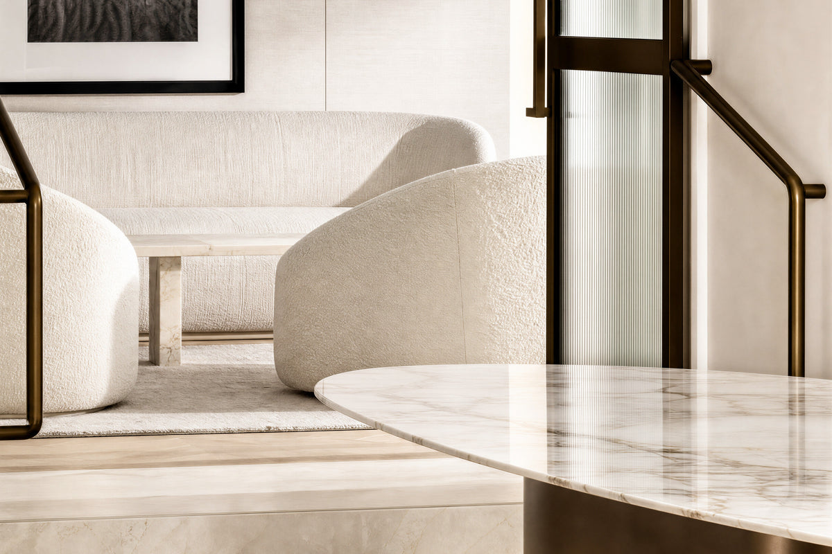 Seating and a stone table beside a bronze-framed doorway in the Private Suite