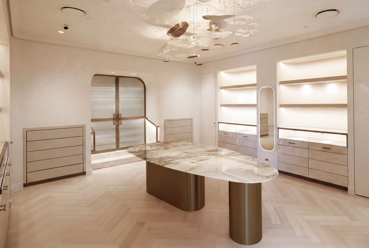 The Three Over Six showroom with a central stone table, illuminated displays and bronze-framed doors