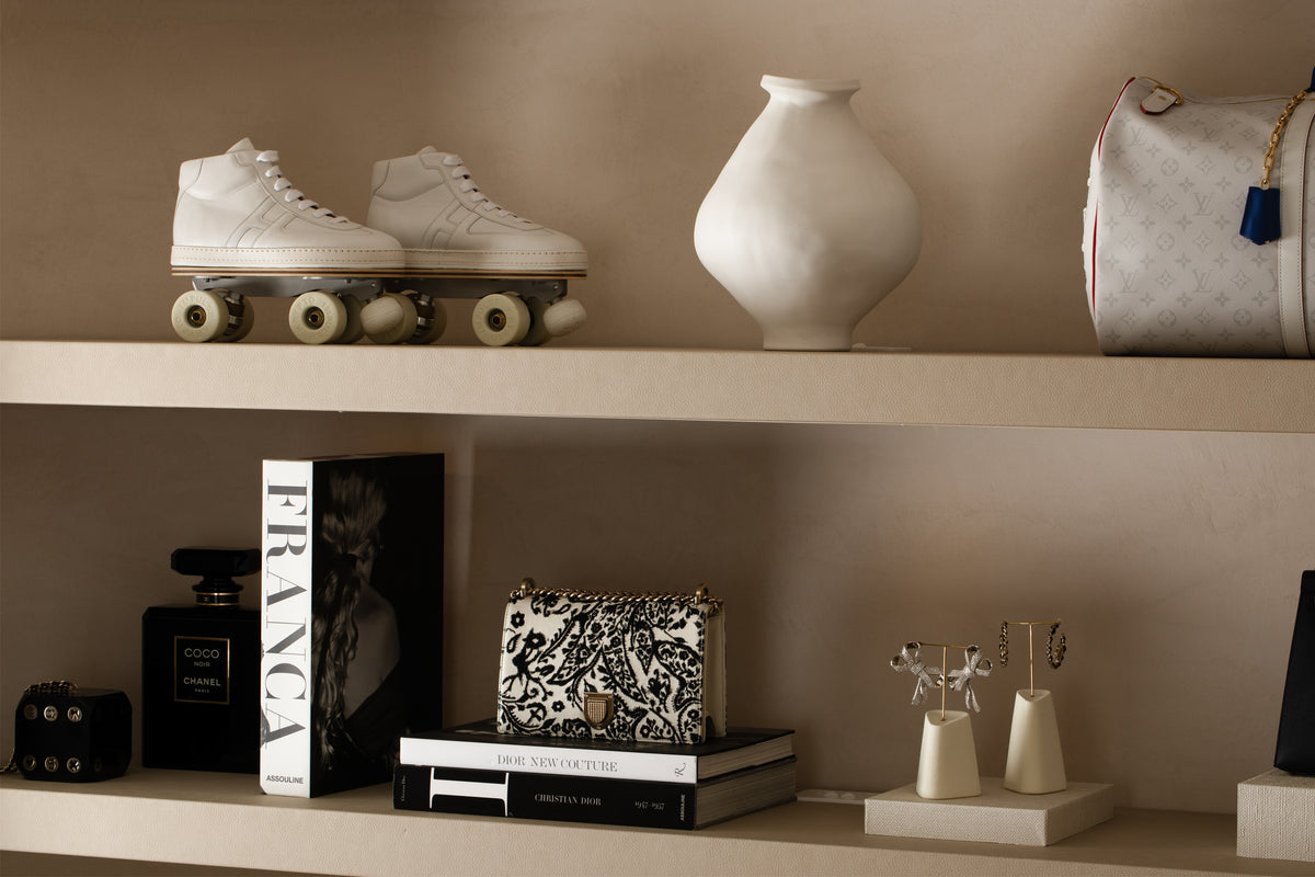 Roller skates, a ceramic vessel, handbags, books and jewellery arranged on shelves at Three Over Six