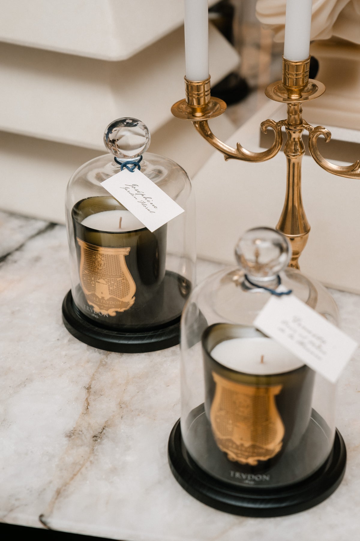 Trudon candles beneath glass cloches.