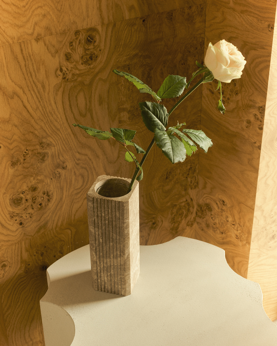 Greg Natale Celesta Vase Light Emperador with a white rose on a sculptural pedestal