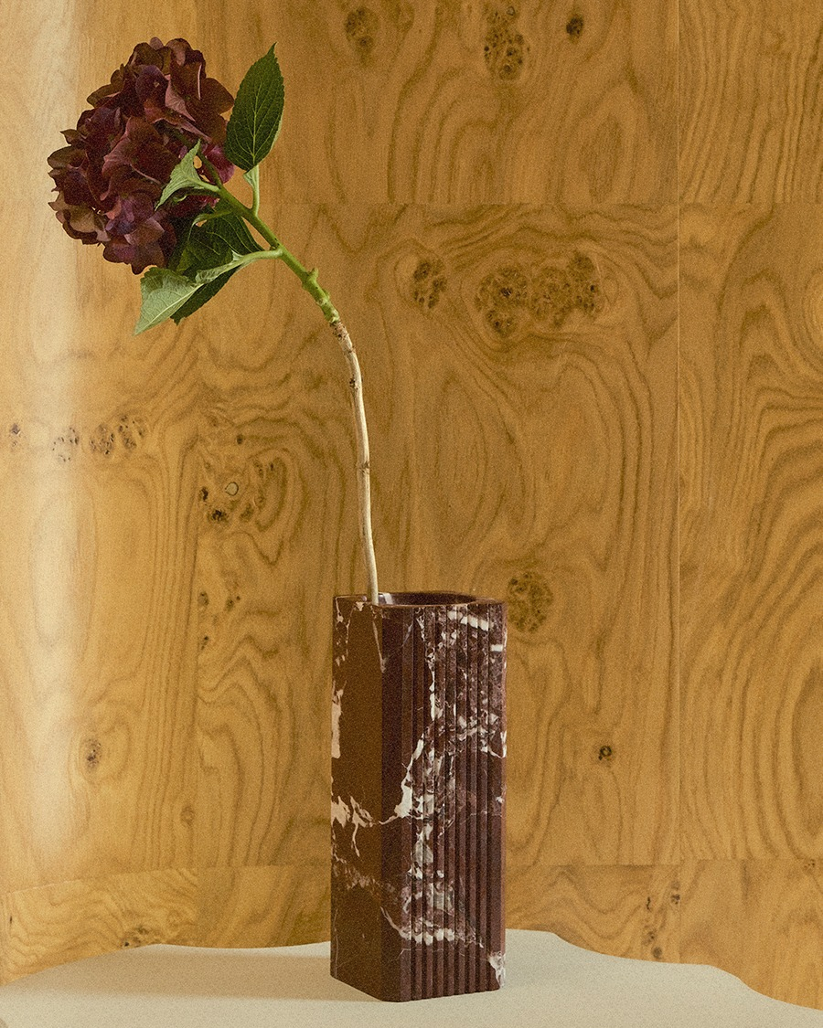 Greg Natale Celesta Vase Merlot with a burgundy hydrangea on a sculptural pedestal