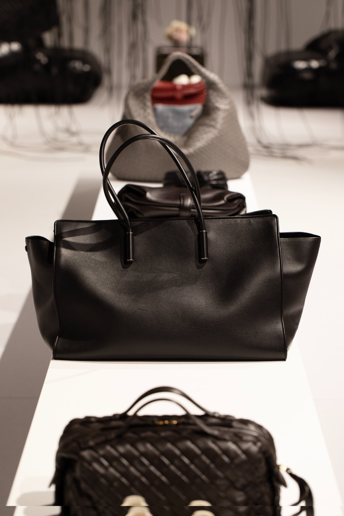 Black leather handbag displayed among bags at Bottega Veneta in Sydney