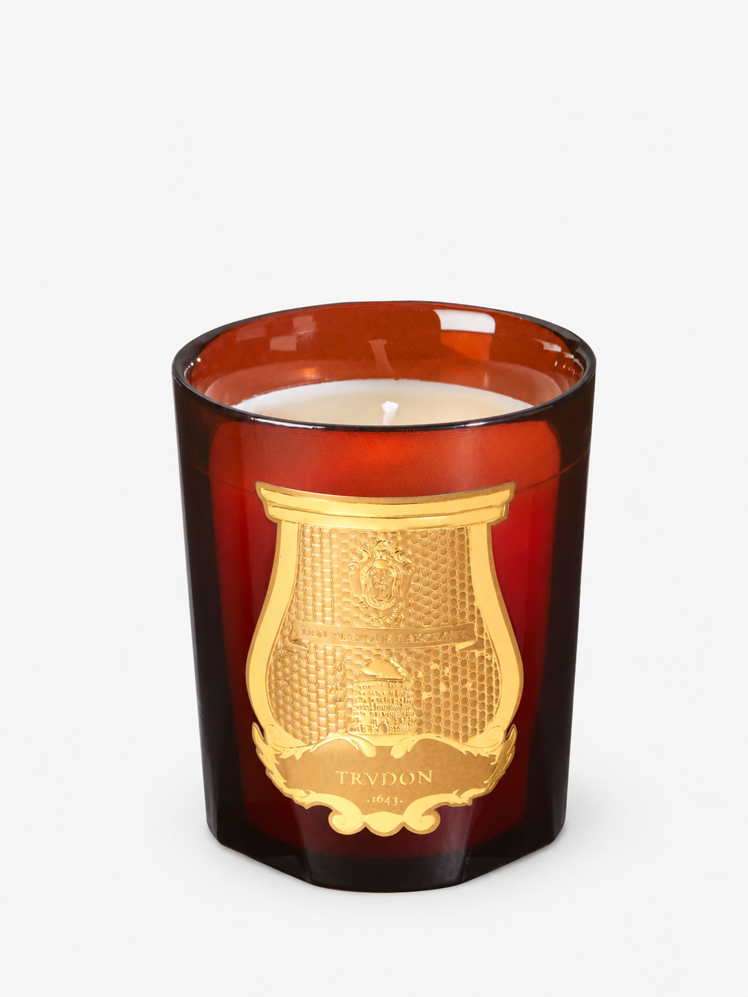 Trudon Cire Classic candle in amber glass, with a soft studio contact shadow.